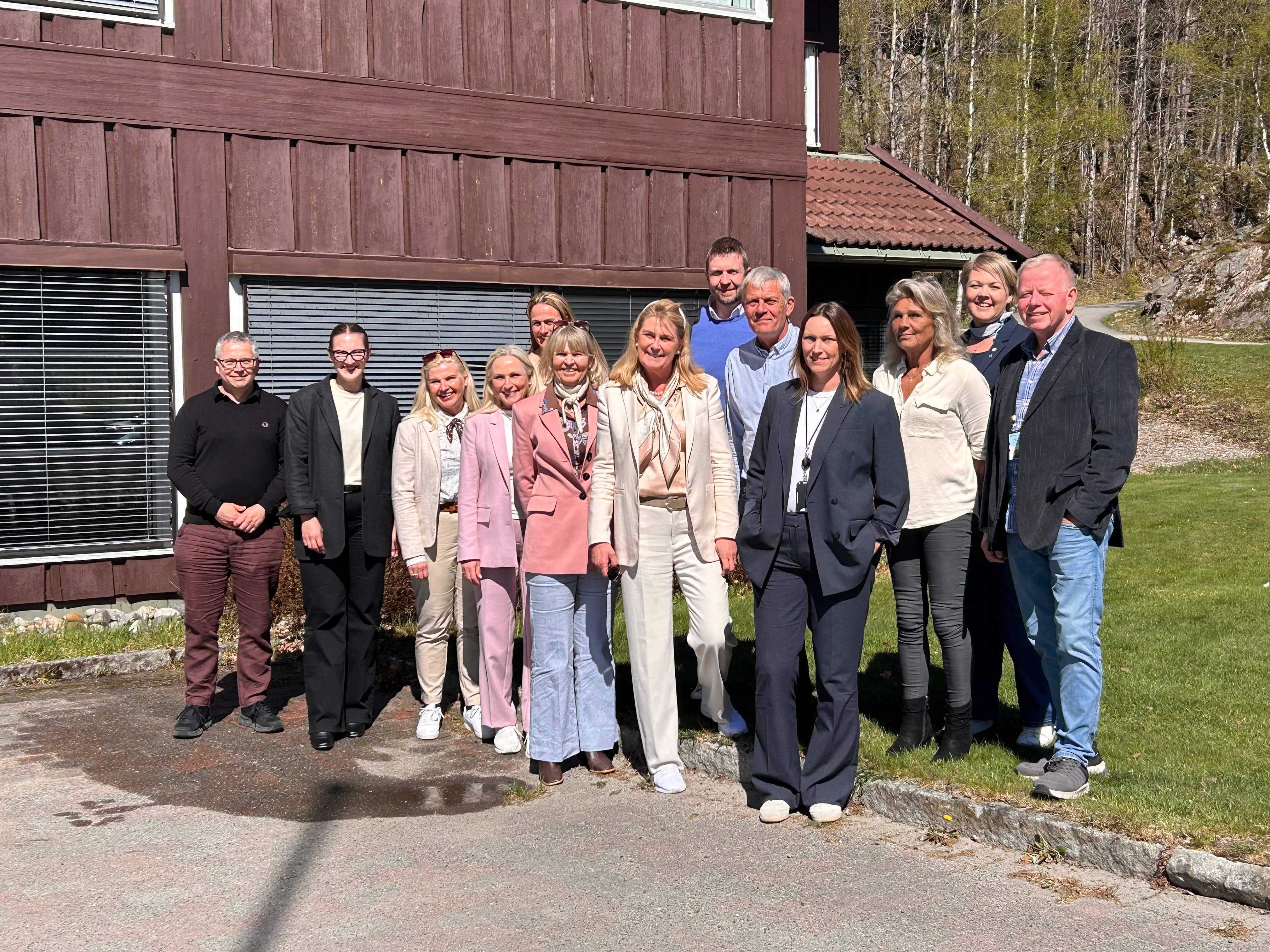 En gruppe smilende mennesker utendørs.