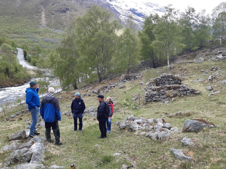 Fjell, folk, grønne trær, snø, elv
