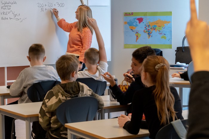 lærer underviser på whiteboard foran elevene