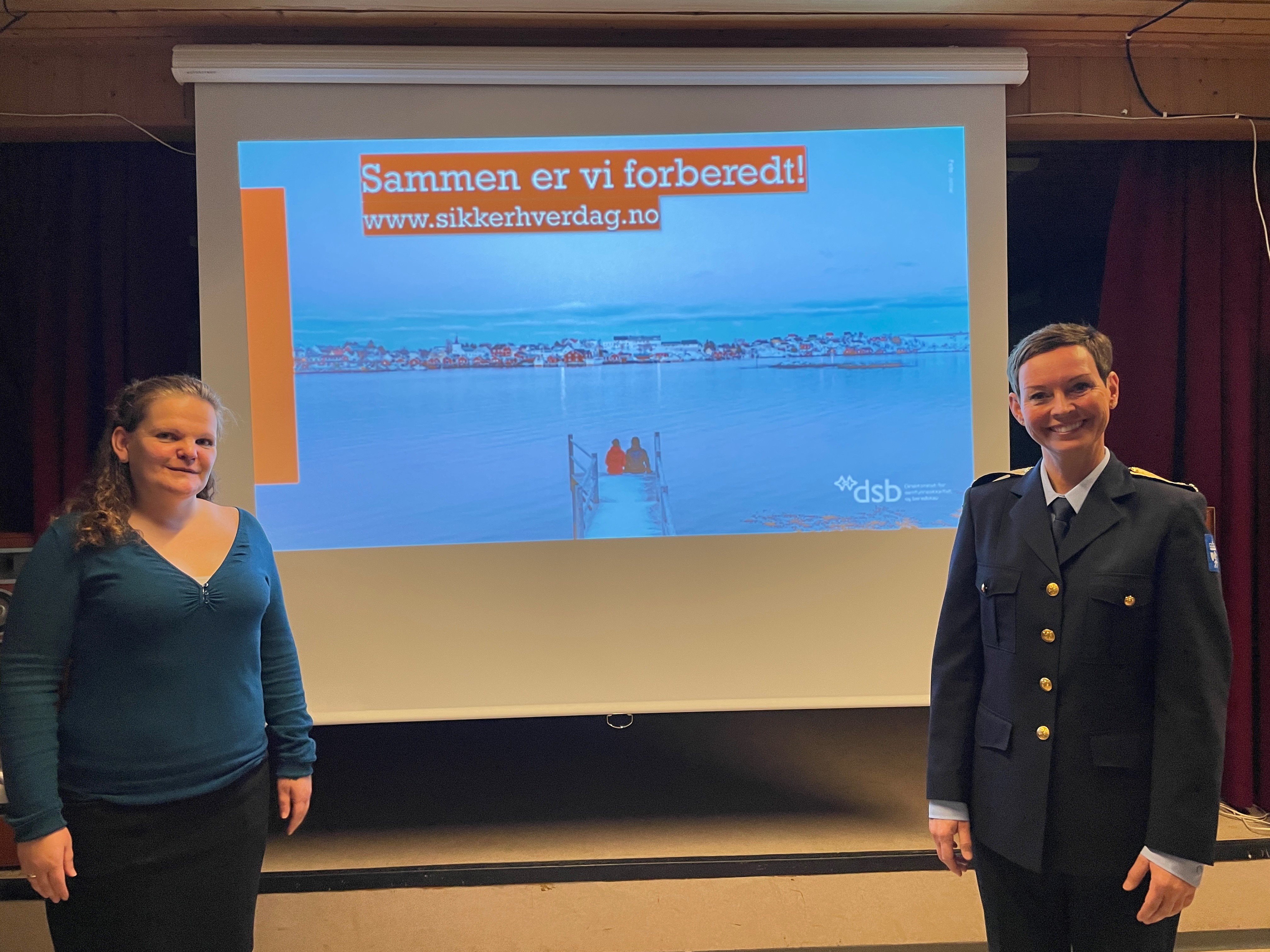 To damer fremfor et lerret som viser en presentasjon.