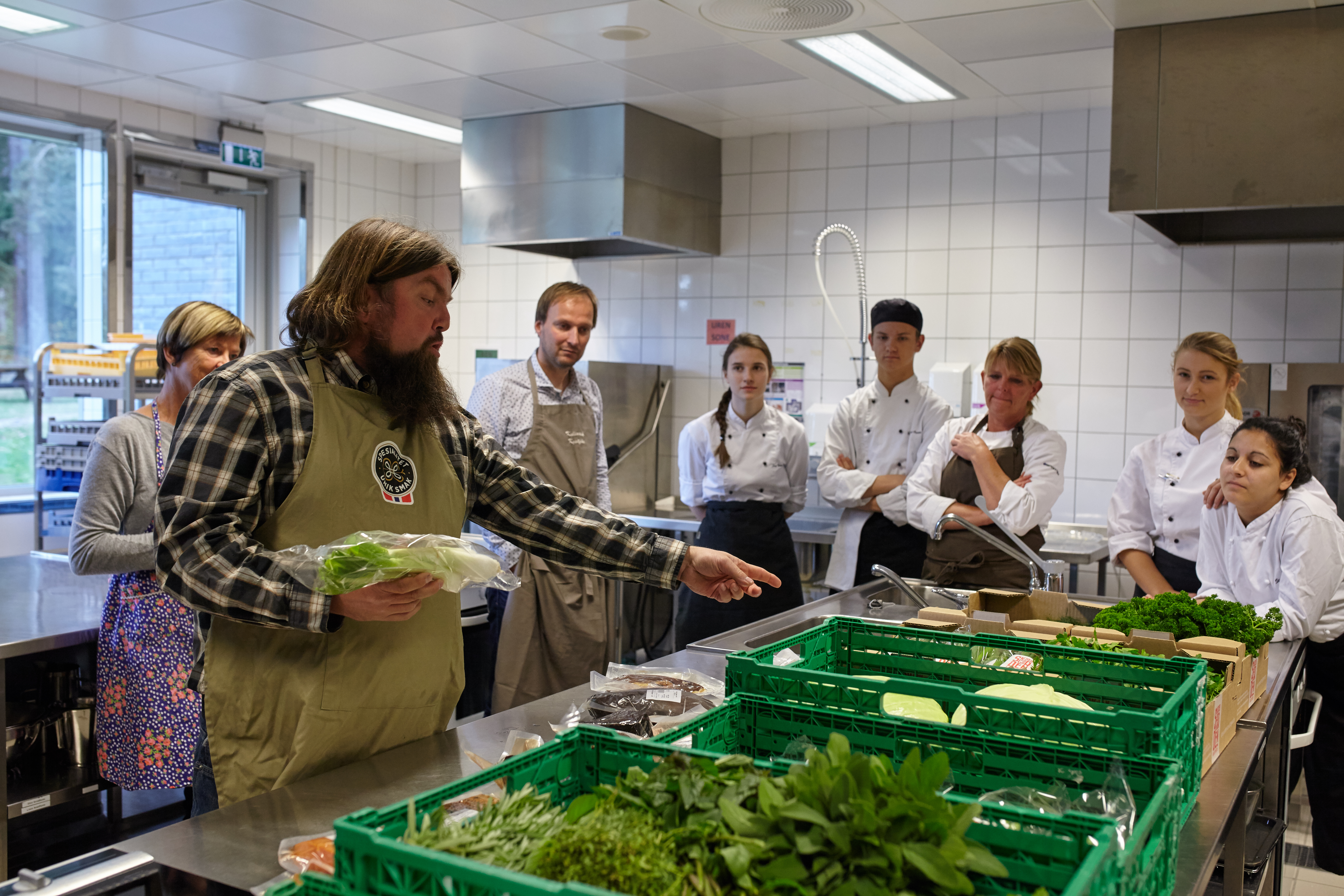 Folk som prater om gode råvarer til mat på et institusjonskjøkken.