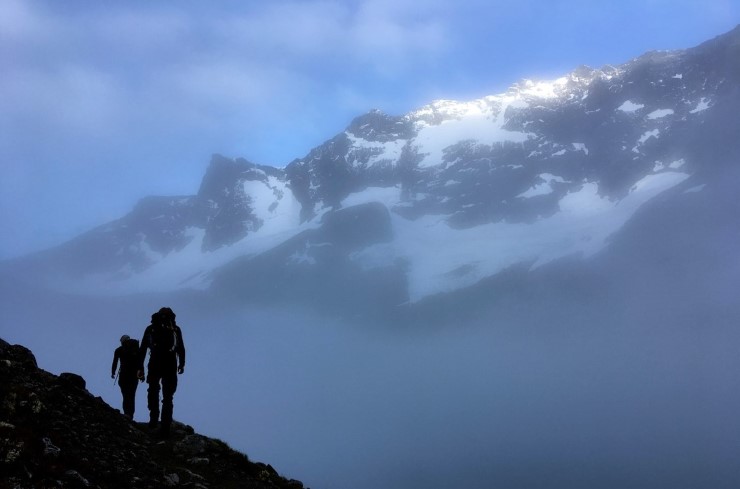 To fjellklatrarar i morgondis på ein fjelltopp