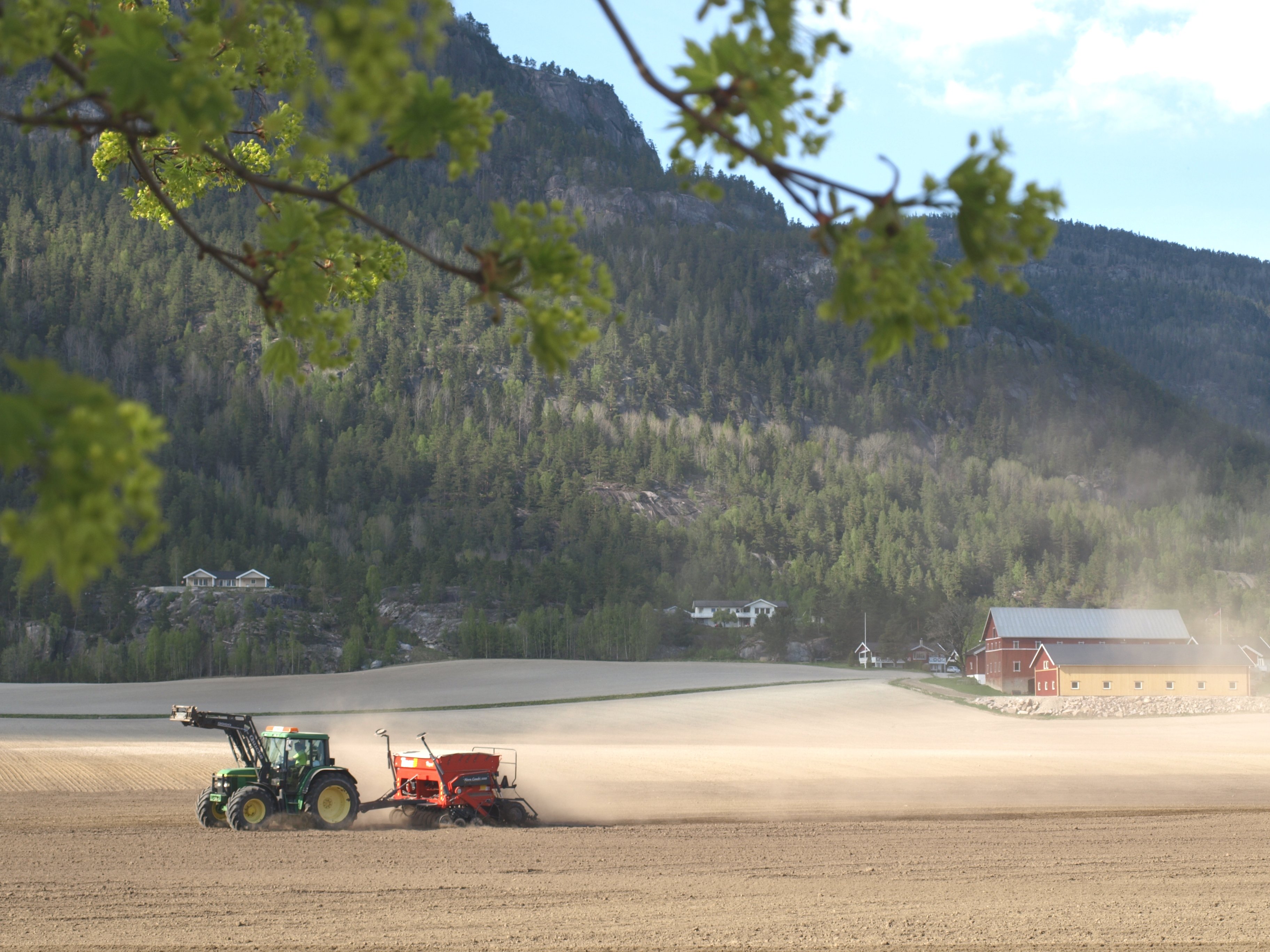 Traktor som kjører på jordet