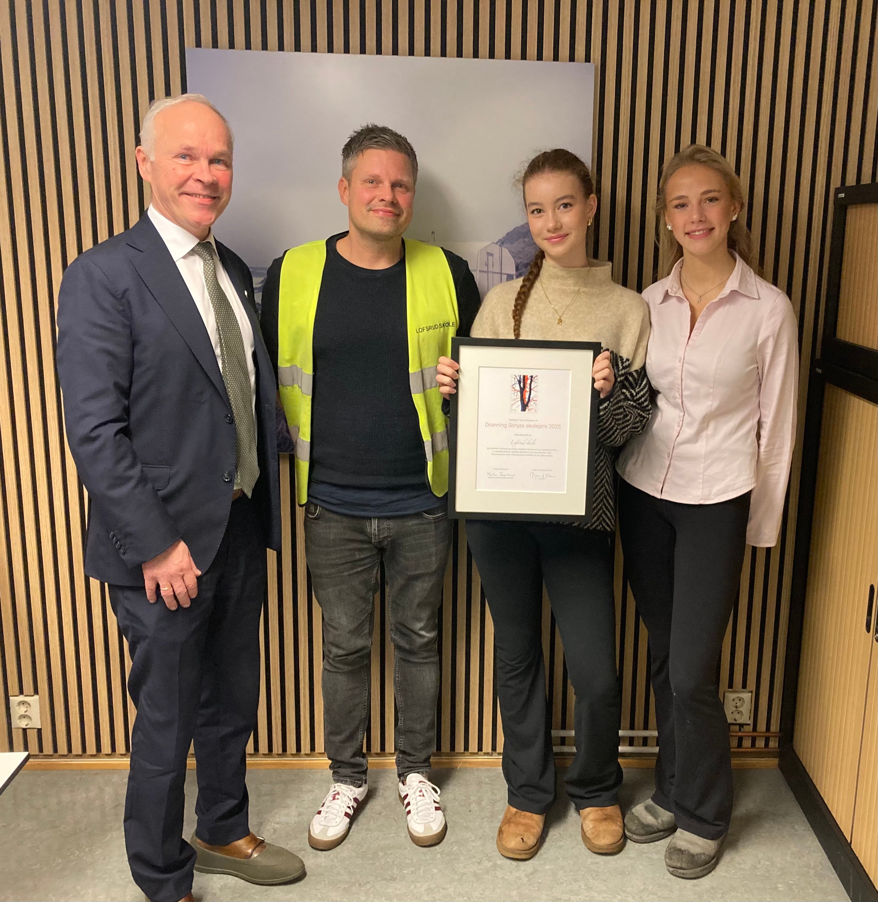 Statsforvalter Jan Tore Sanner deler ut diplomet til rektor Trond Nilsen og Emma Marie Bretting Øvrebø og Sunniva Johannessen Buckley fra elevrådet.