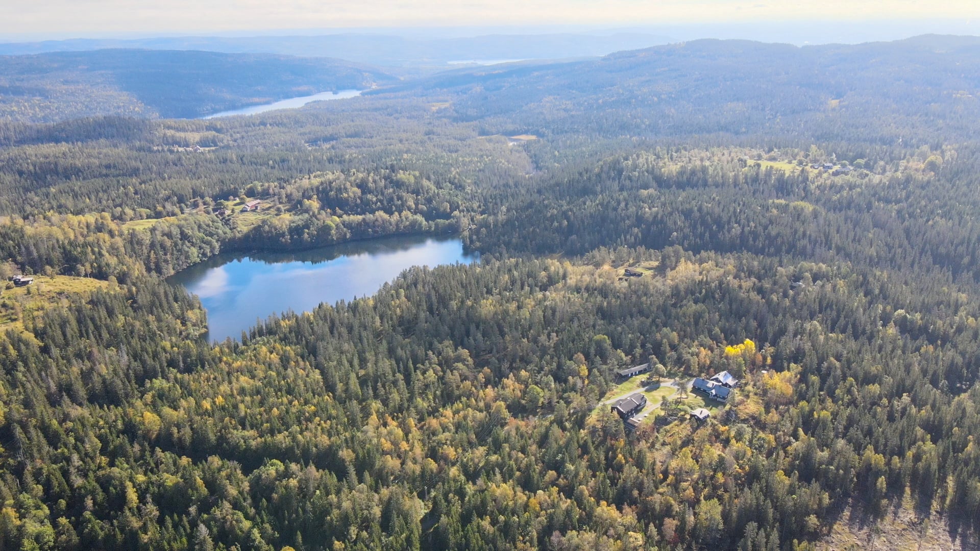 Landskapsbilde med skog, vann og kulturmarker 