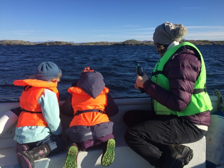 to born som fiskar med ei kvinne i kystlandskap frå båt