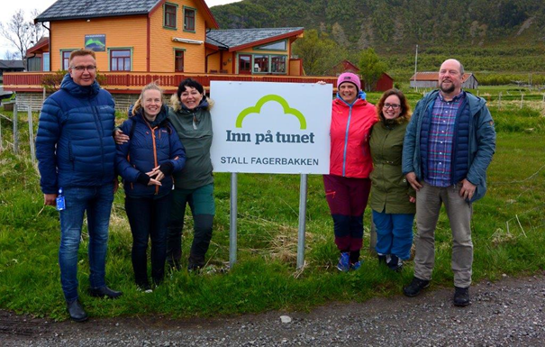 Bilde av personer fra Hadsel og i Vågan kommuner ved Inn på tunet-skilt på Stall Fagerbakken.
