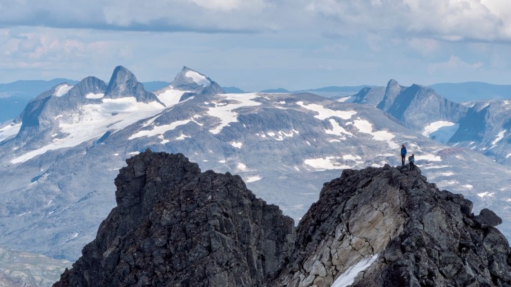 to menneskje på fjellrygg i høgfjellslandskap