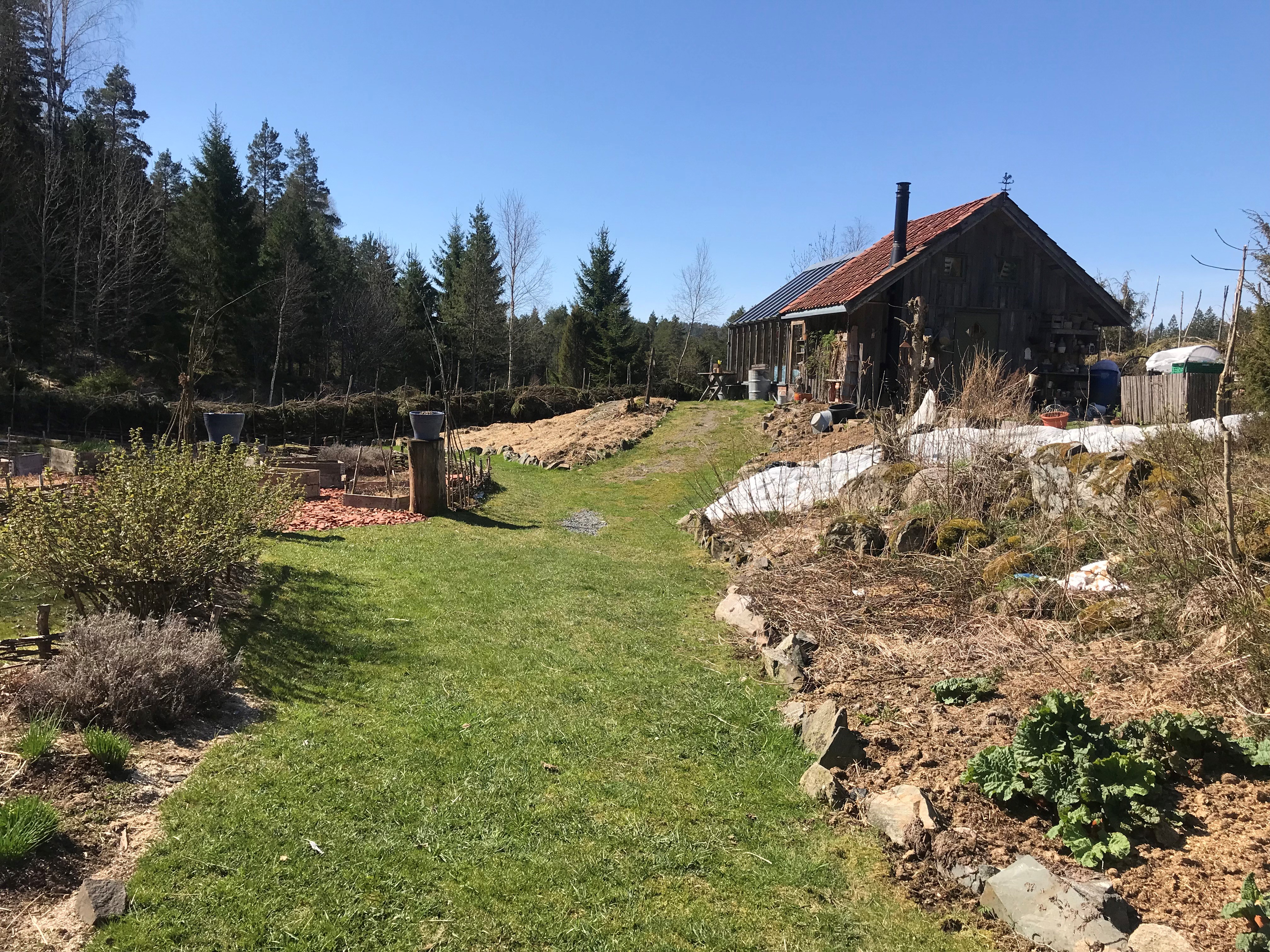Gammel bygning, grønt gress, dyrkingsbed