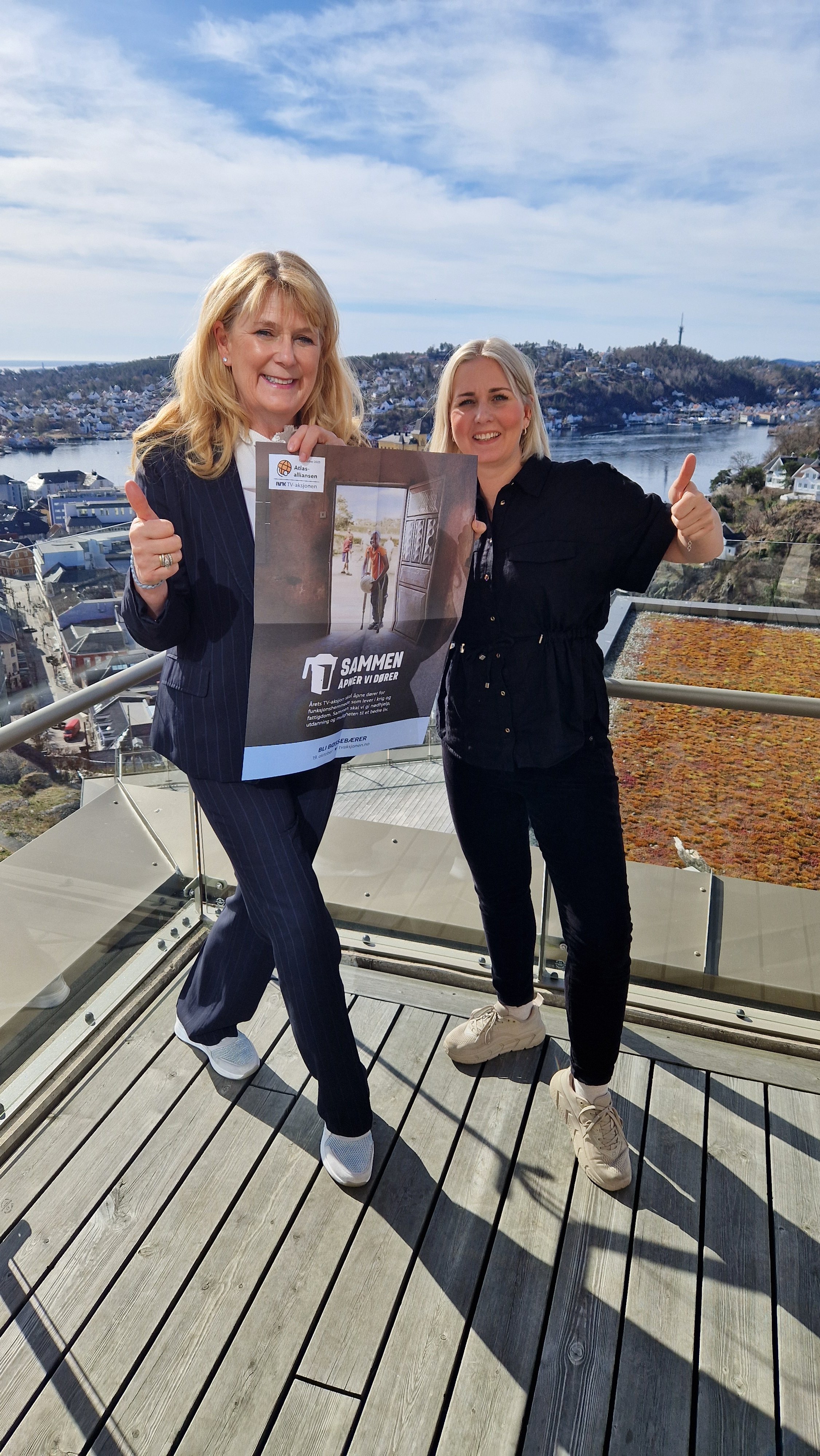 Gina Lund og Helene Knutsen Fosso holder plakat med teksten "Sammen åpner vi dører"