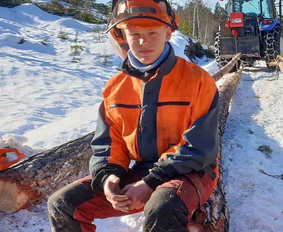 Skogsarbeider sitter på tømmerstokken 