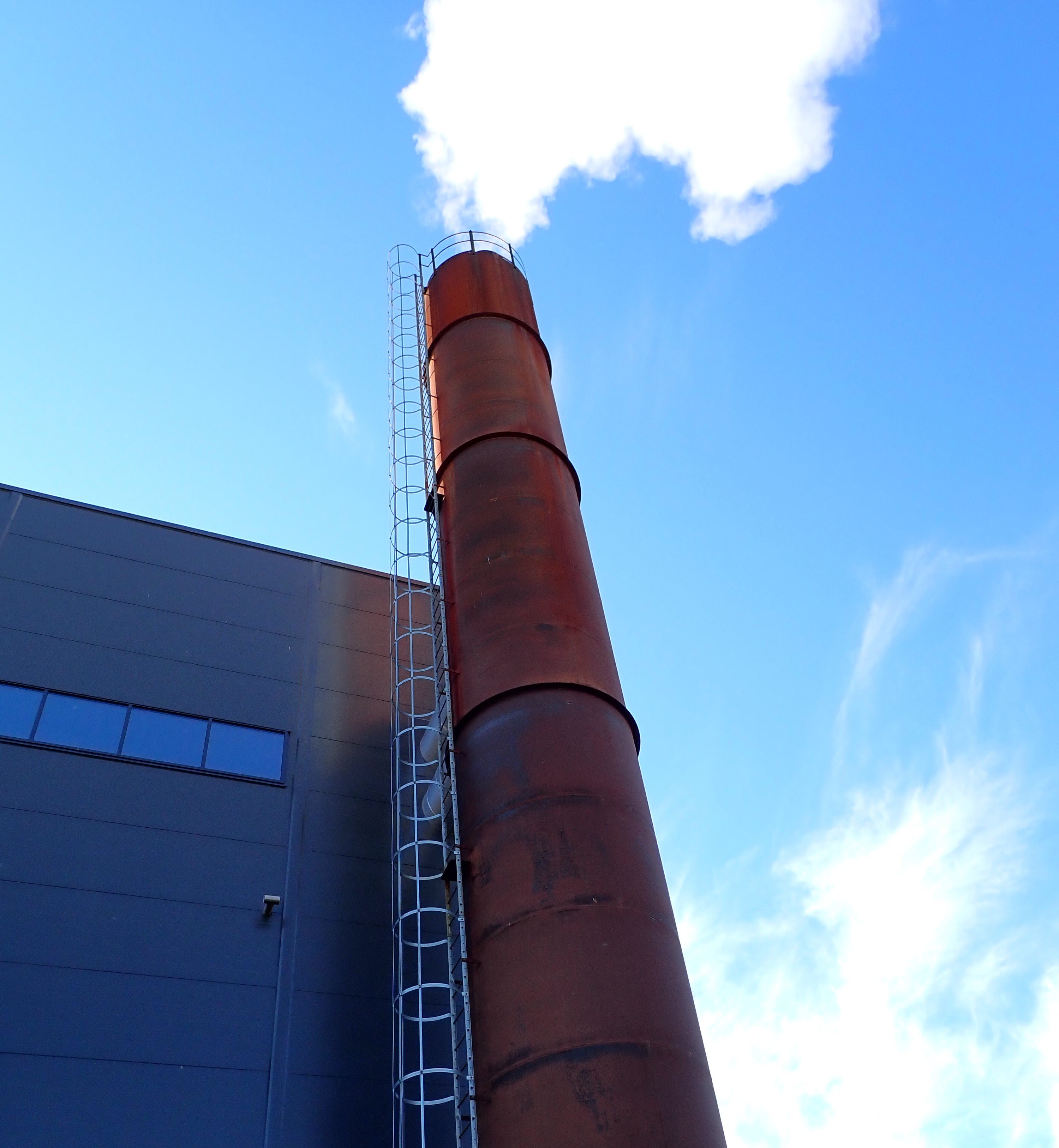 Utslipp av hvit røyk fra industriell pipe.