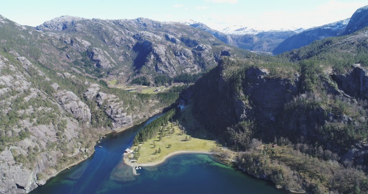 landskap med elveutløp i midten og skog på kvar side