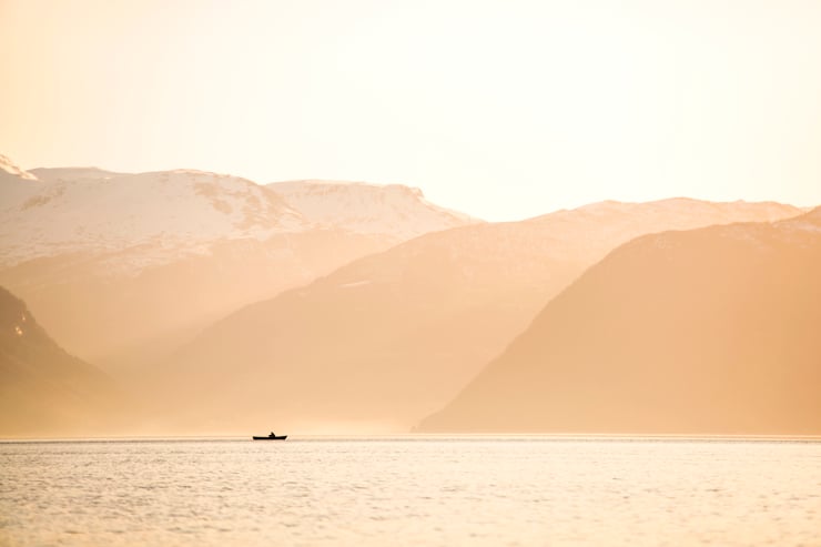 en robåt i eit landskap med fjell og fjord