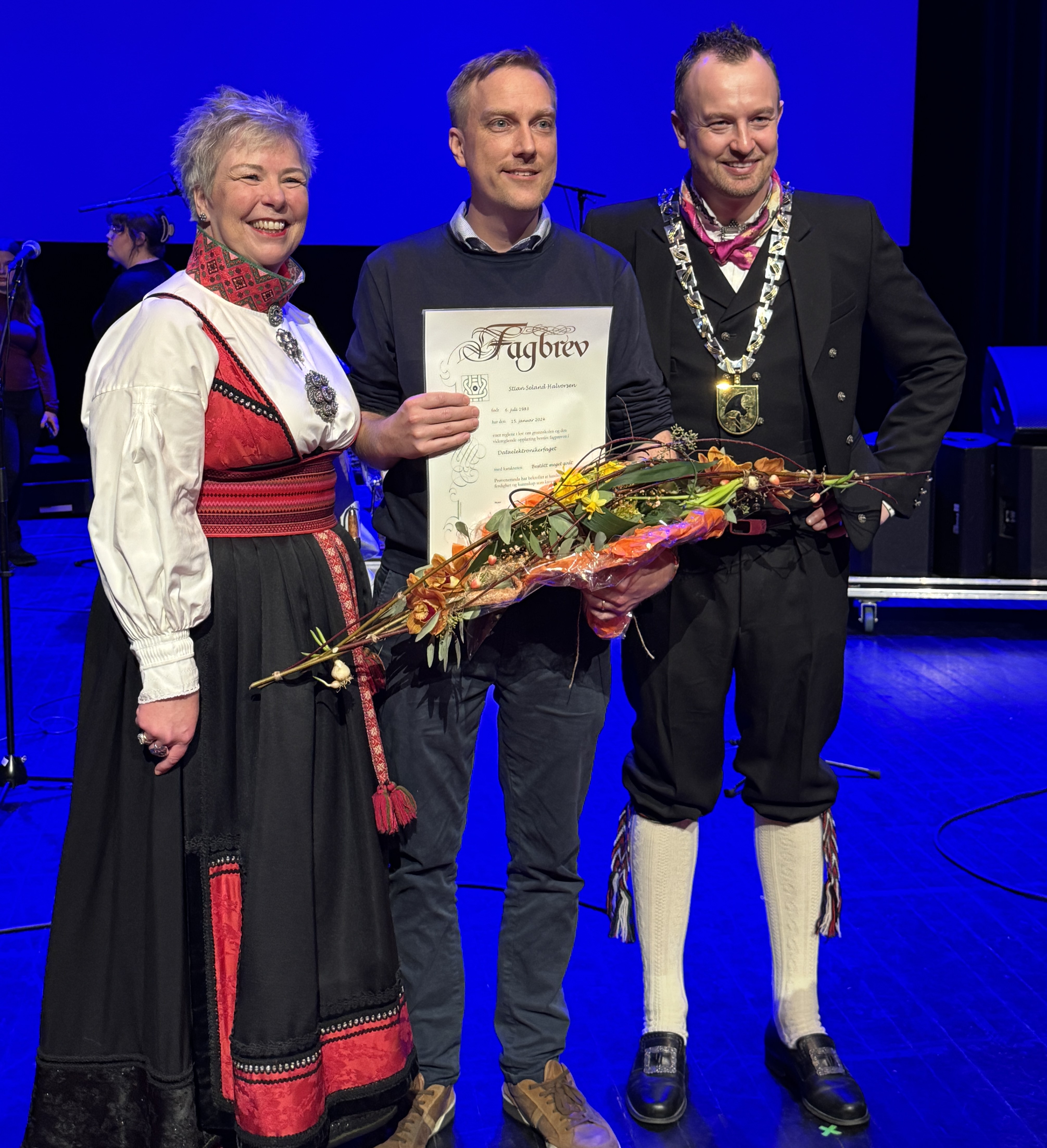 Stian Seland Halvorsen mottar prisen for årets lærling. Her er han på scenen med fylkesordfører i Telemark, Sven Tore Løkslid.