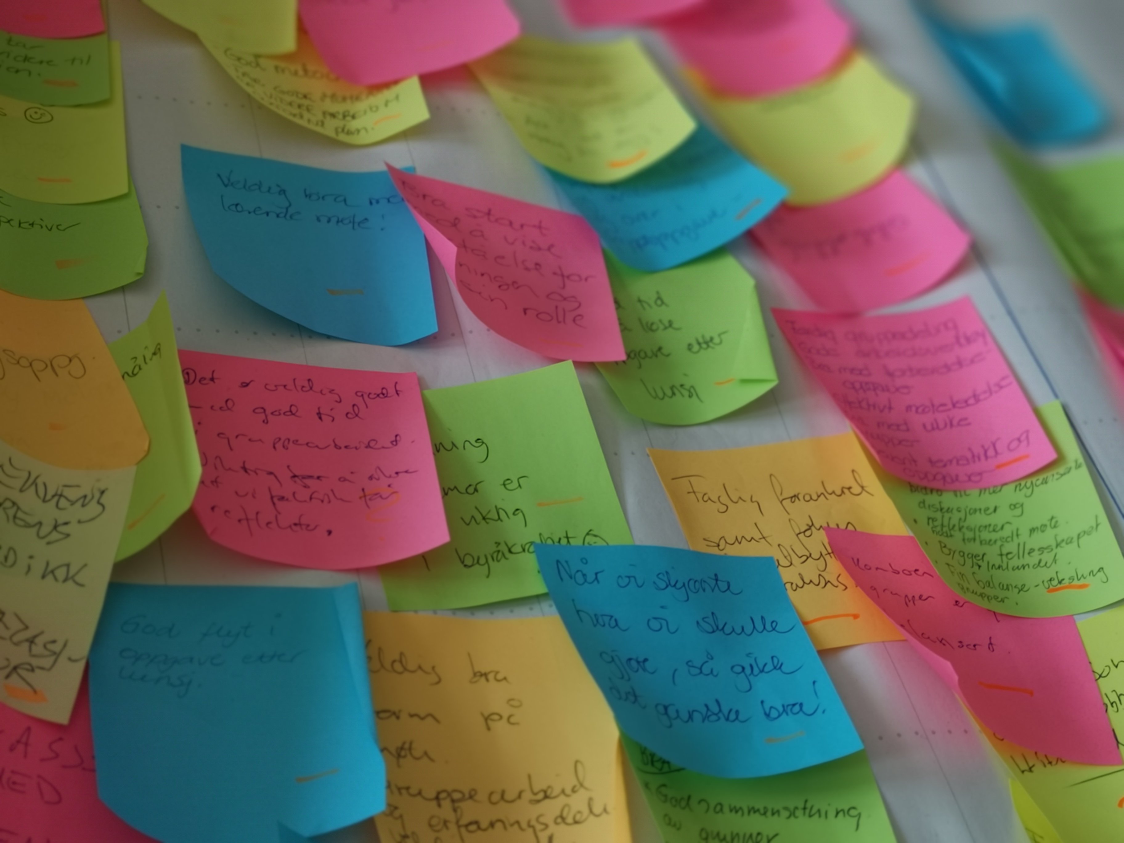 Post-it lapper i forskjellige farger klistret på et stort ark