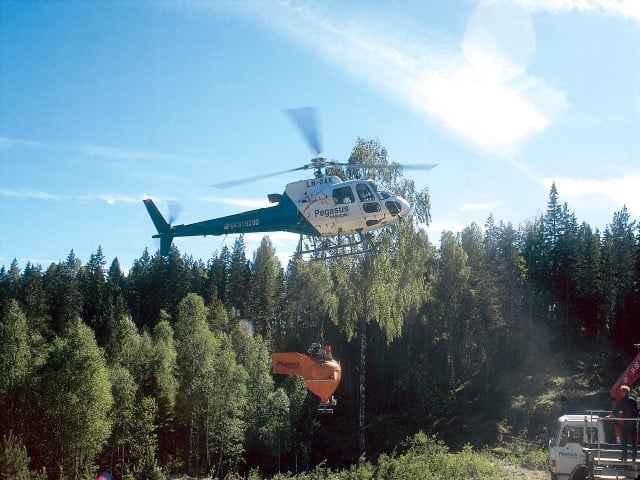 Foto av helikopter som bidrar til gjødsling av skog.
