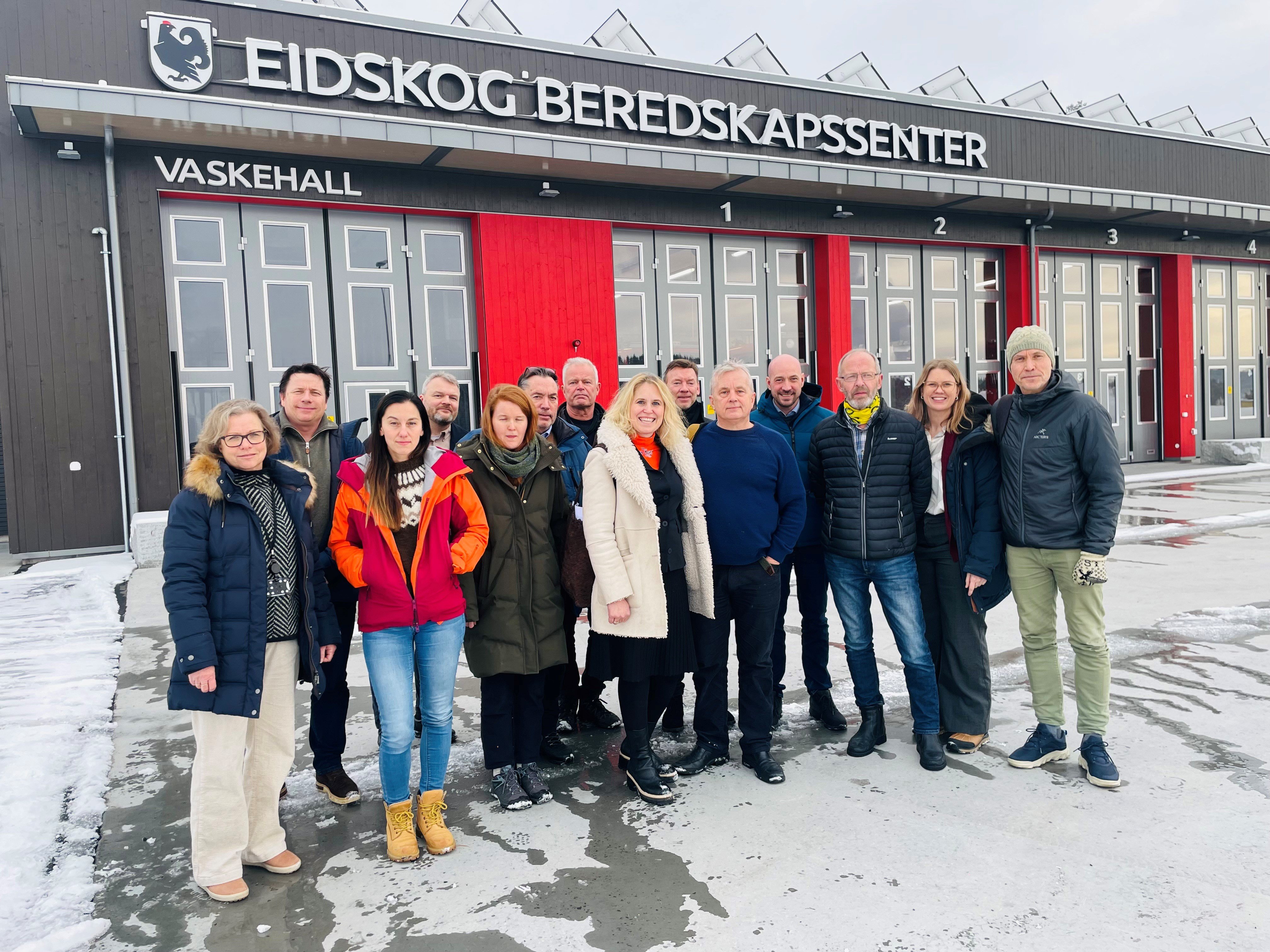 Mange mennesker står foran en stor bygning.